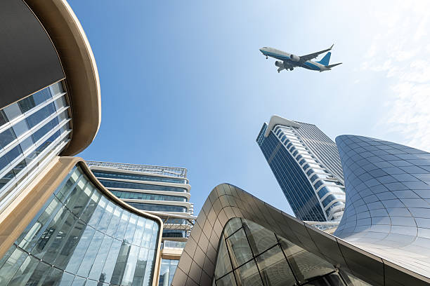 istock Looking up at modern office buildings, watching planes fly by 2253765860
