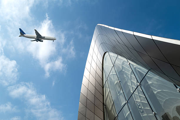 istock Looking up at modern architectural shapes to see airplanes 2253765874