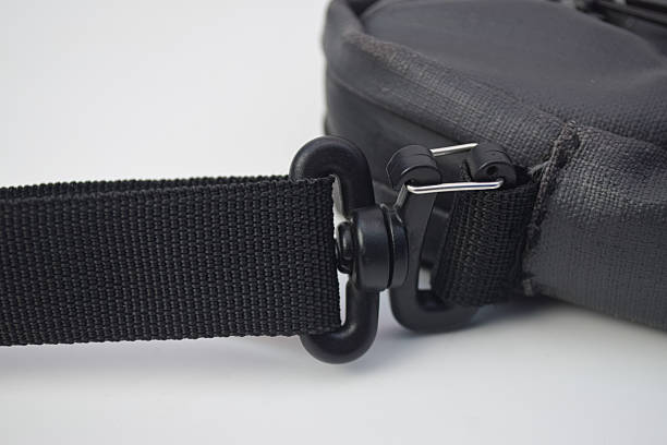 istock Detailed view of a black plastic swivel snap hook attached to a nylon webbing shoulder strap on a bag 2253766319