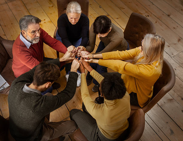 istock Multiethnic  group support session with adults sharing emotions indoors , holding hands 2253767243