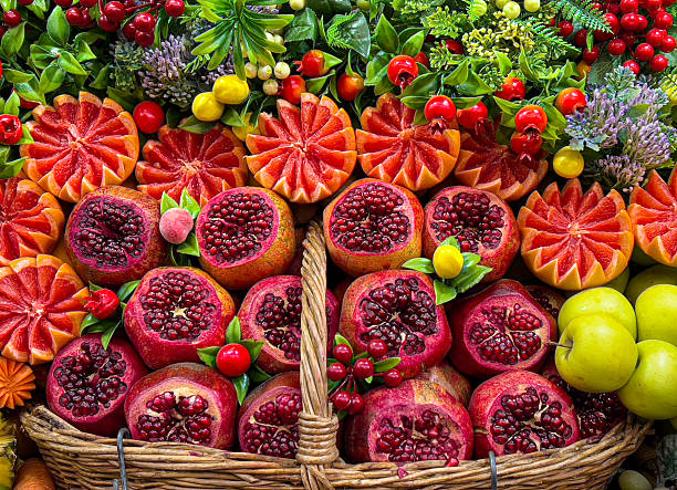 Fresh pomegranates and citrus slices in woven basket