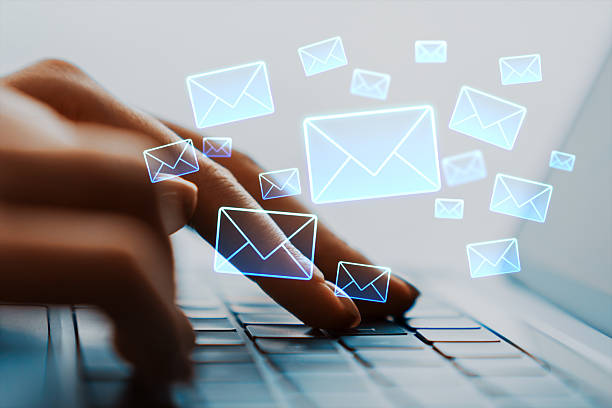 istock Person typing on laptop keyboard with glowing email icons floating above representing digital communication and online messaging concept. 2253770817