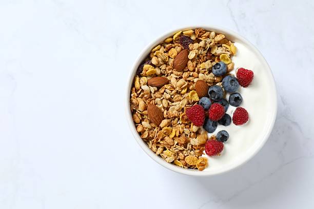 istock Delicious granola with berries and yogurt on a light background 2253770818