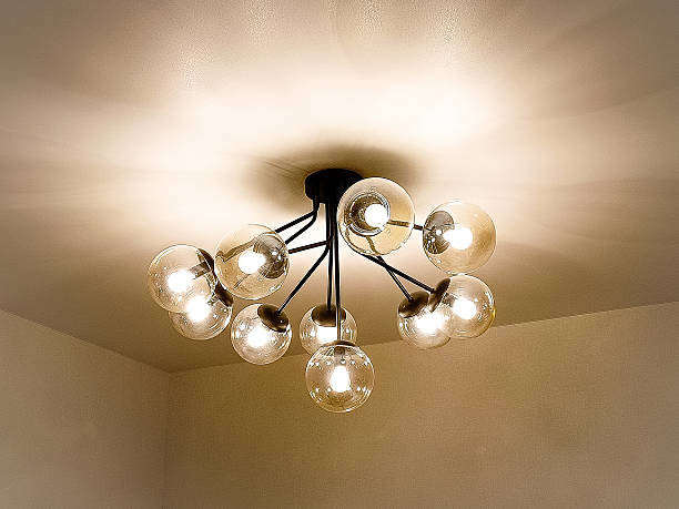 A modern electric light fixture on the ceiling in the room.