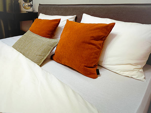 istock Multicolored soft pillows lie on a made bed. Close-up. 2253773277