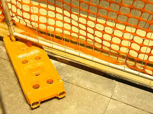 istock Urban construction site with orange safety barrier and traffic divider on pavement 2253774971