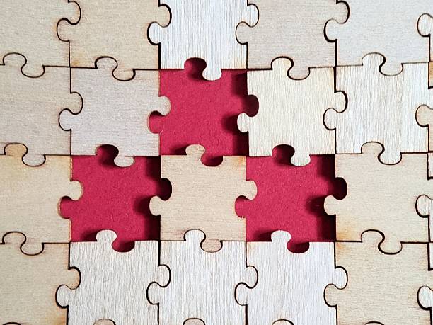 istock Wooden jigsaw puzzle highlighting missing pieces against a vivid red background, symbolizing gaps in structure, knowledge, understanding or strategic misalignment. Copy space 2253775444