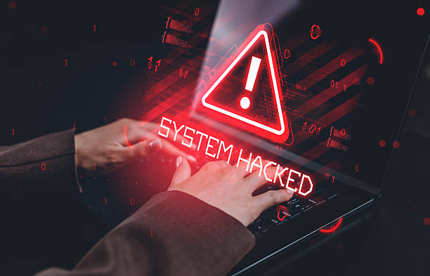 istock Hands typing on laptop with red warning sign and 