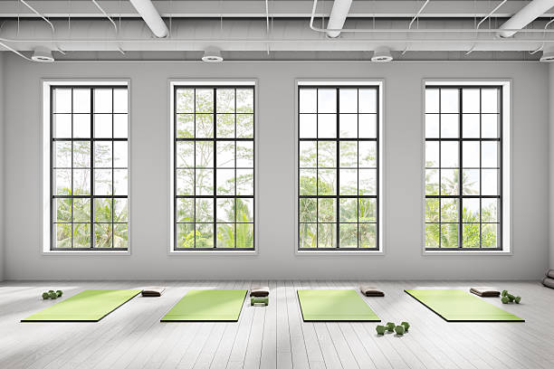 istock Modern yoga studio interior with large windows, green mats, and minimalist design in bright natural light setting. Peaceful wellness atmosphere.. 3D Rendering 2253776497