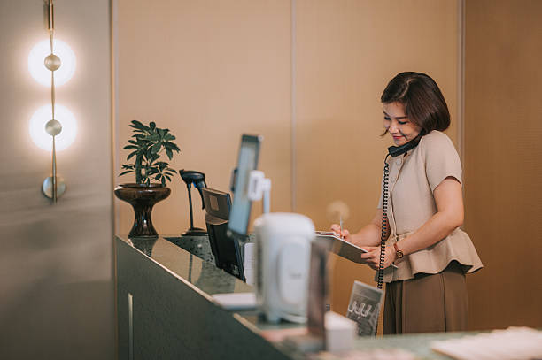istock Asian Chinese female Spa receptionist taking a phone booking at front desk 2253781435