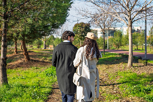 Young couple enjoying a romantic walk in a park on a sunny day
