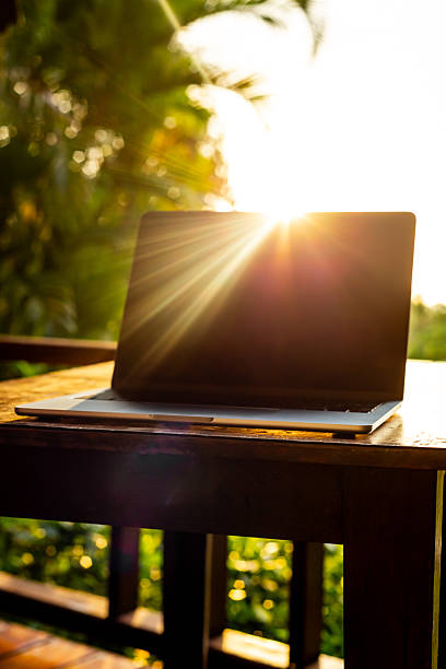 istock Laptop with backlight on wooden table on terrace in tropical forest at sunset, remote work digital nomad 2253784498