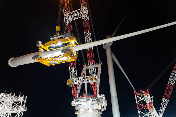 Wind turbine blade lifted and swinging over to the nacelle to be installed from the offshore construction vessel