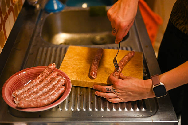 istock Person preparing fresh sausages in kitchen sink 2253789664