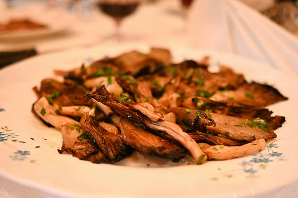 Cooked oyster mushrooms seasoned with fresh herbs on a white plate