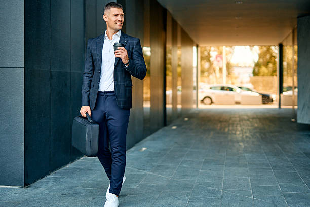 istock Businessman walking with briefcase and coffee cup 2253794095