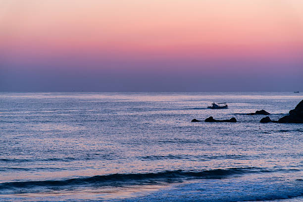 Fishing boat at sunset sailing off of the Provincial capital city of Victoria  on Vancouver Island, British Columbia