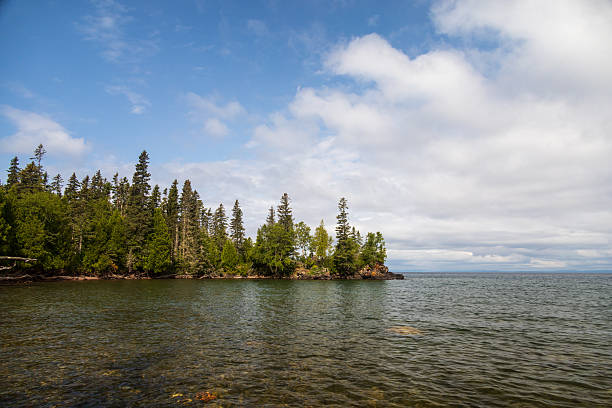 View of Lake Superior with pine trees and white clouds on Isle Royale Nationl Park