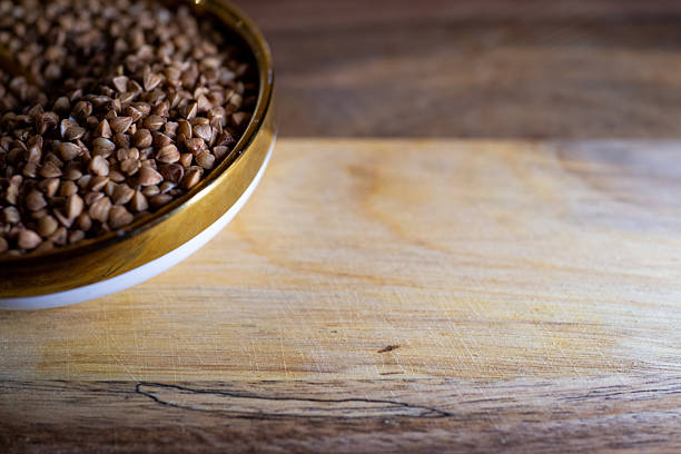 closeup buckwheat bowl on wooden board, warm natural light, rustic ceramic bowl partially in frame, textured