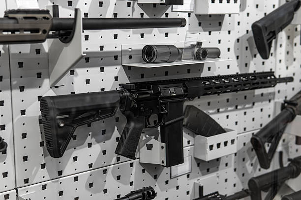 istock Modern assault rifle on a white pegboard exhibition wall in a gun shop. 2253799982