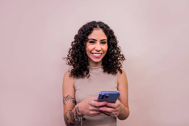 istock Portrait of a young woman using mobile phone - Studio Shot 2253802604