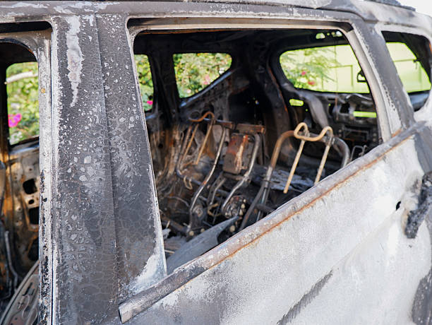 car destroyed by fire, featuring a charred interior with burnt seat frames and peeling paint. Ideal for insurance, disaster, or crime-related themes