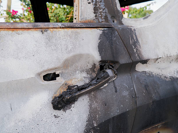 car destroyed by fire, featuring a charred interior with burnt seat frames and peeling paint. Ideal for insurance, disaster, or crime-related themes