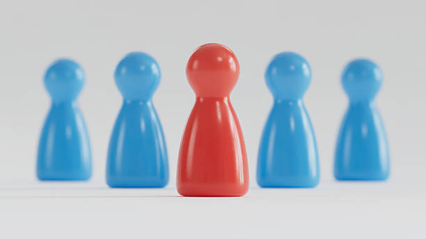 istock Standout Red Token: Contrast in a Group of Blue Game Pieces 2253804258