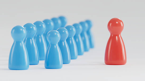 istock Standout Red Token: Contrast in a Group of Blue Game Pieces 2253804266