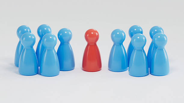 istock Standout Red Token: Contrast in a Group of Blue Game Pieces 2253804287