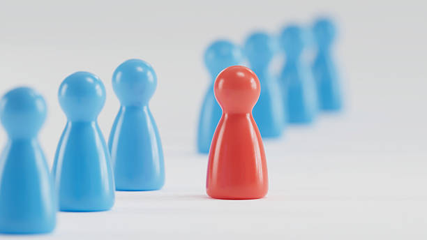 istock Standout Red Token: Contrast in a Group of Blue Game Pieces 2253804319
