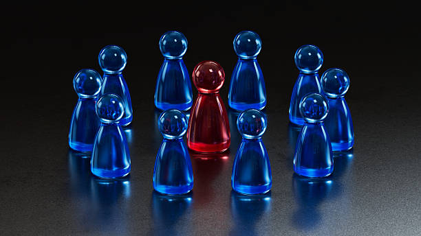 istock Standout Red Token: Contrast in a Group of Blue Game Pieces 2253805763