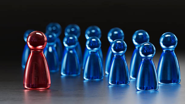 istock Standout Red Token: Contrast in a Group of Blue Game Pieces 2253805764