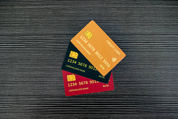 istock Three Colorful Credit Cards Stacked Nicely On A Dark Textured Background With Studio Lighting 2253806278