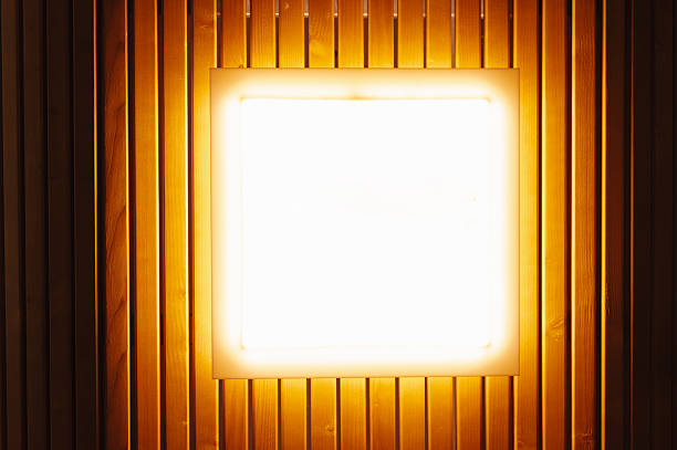 Glowing Square Light On Wooden Wall Soft Amber Illumination Highlights Vertical Grain And Textured Panels Creating Intimate Cozy