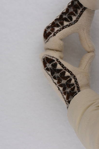 istock Hands in warm knitted mittens forming a heart on snow, top right 2253806466