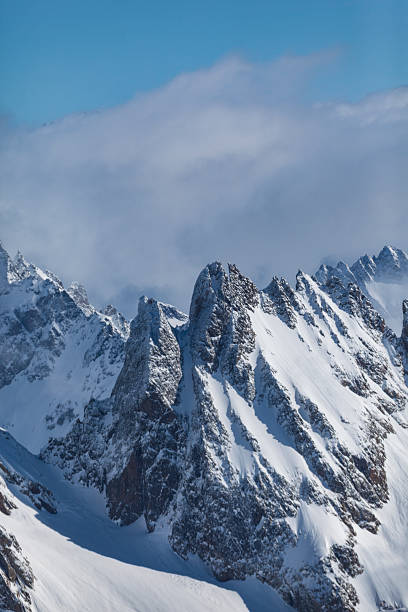 Jagged, snow-covered alpine peaks rising sharply above the surrounding slopes near Mount Titlis, Switzerland. Winter mountain scene highlighting rugged terrain, elevation and dramatic alpine geology.