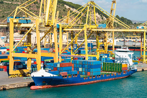 istock Cargo ship docked at container terminal with yellow cranes 2253809431