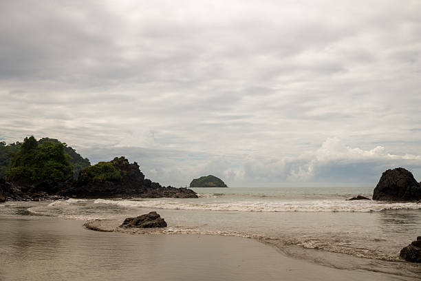 The beach at Playa Espadilla in Manuel Antonio, Costa Rica on a cloudy day.