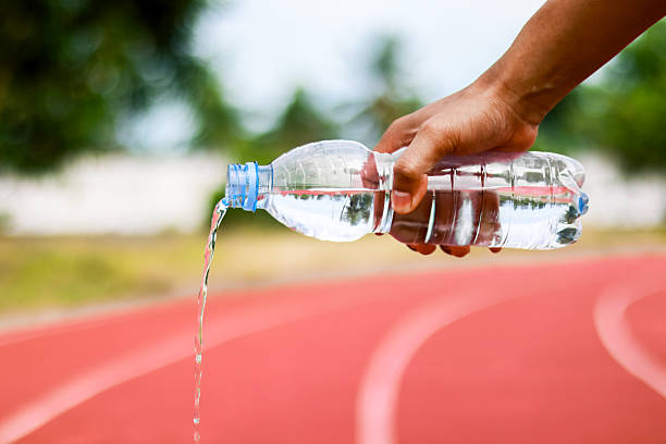 istock Runner pouring water from bottle on track, hydration and refreshment concept 2253813134