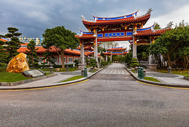 Traditional Chinese Buddhist monastery entrance in Singapore with ornate gate, symmetrical path, and peaceful garden atmosphere.