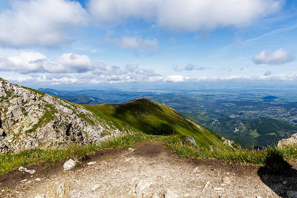 Breathtaking panoramic view from a mountain summit overlooking a vast valley and distant city. Perfect for real estate, travel, and environmental concepts.