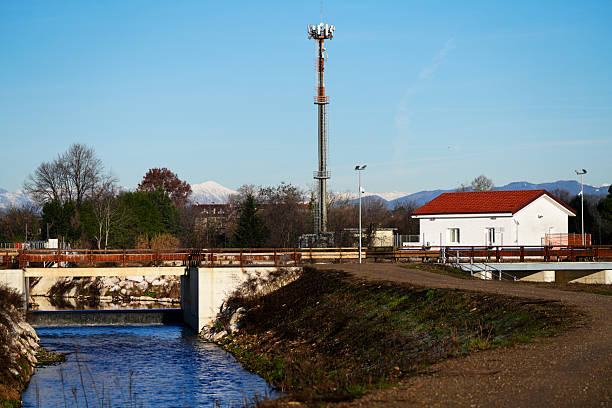 A communications tower full of a variety of antennas stands out against a deep, blue, clear sky background.