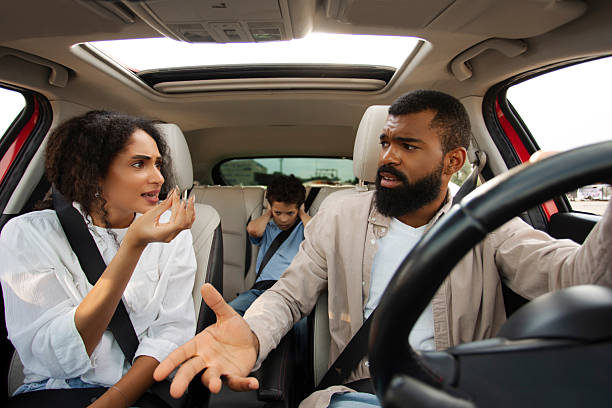 istock Black kid boy feeling sad boring while parent fighting arguing, mom and dad having conflict during car trip, sitting in auto and shouting at each other 2253828165
