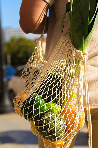 istock Man carrying reusable mesh bag with fresh vegetables 2253833128