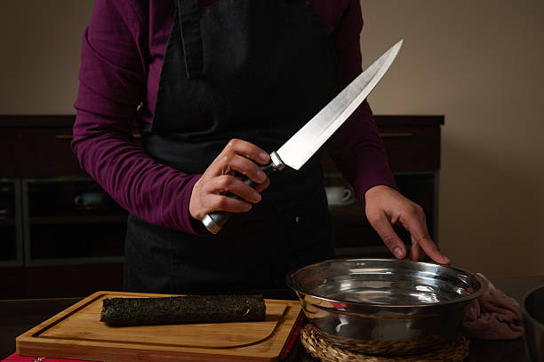 istock Chef With Large Knife Preparing Nori On Cutting Board In Kitchen Studio Setting 2253833353