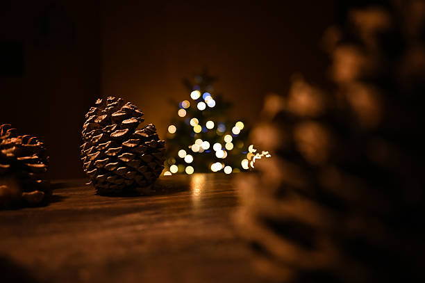 Pinecones creating a cozy holiday atmosphere with a blurred Christmas tree and warm lights