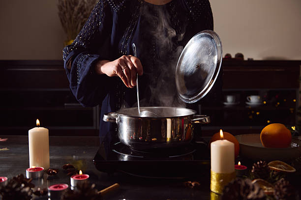 istock Winter Dinner Scene: Woman in Evening Gown Preparing Mulled Wine by Candlelight 2253839979