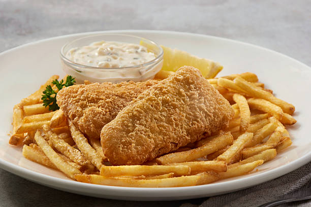 Tempura battered fish served with french fries, tartar sauce, and lemon.