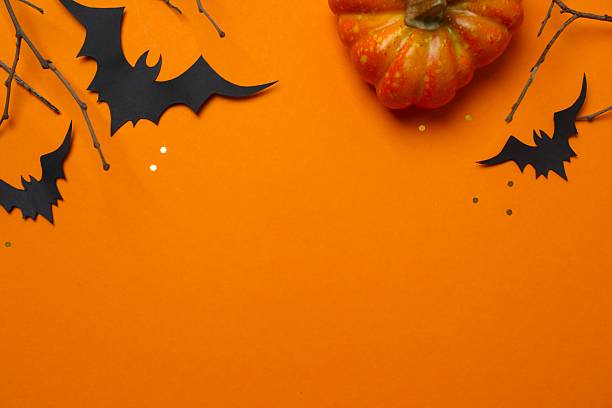 istock Halloween festive background design featuring pumpkins, bats and decorative branches. Halloween concept 2253842089